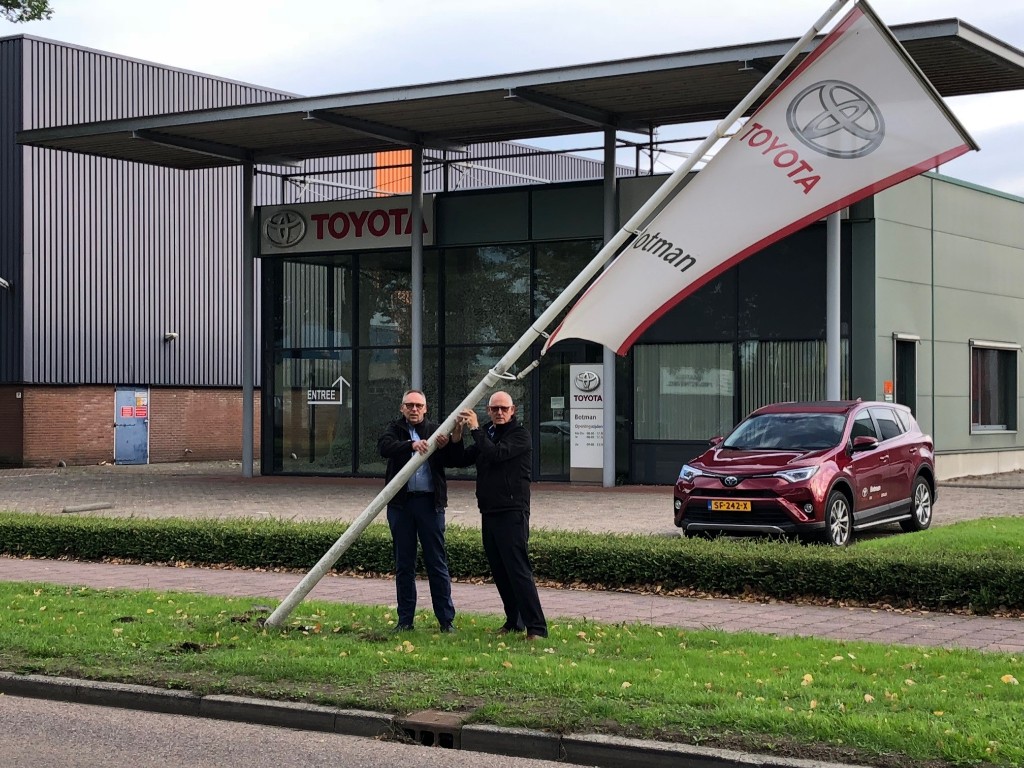 Sjaak en Peter Botman halen de vlag van Toyota Botman naar beneden en sluiten 47 jaar garage Botman in Medemblik af.